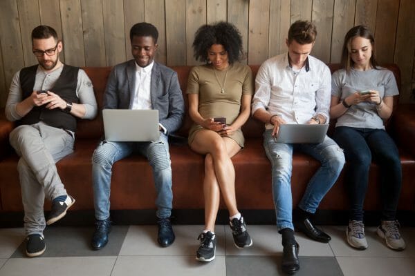 Group of people looking at different electronic devices