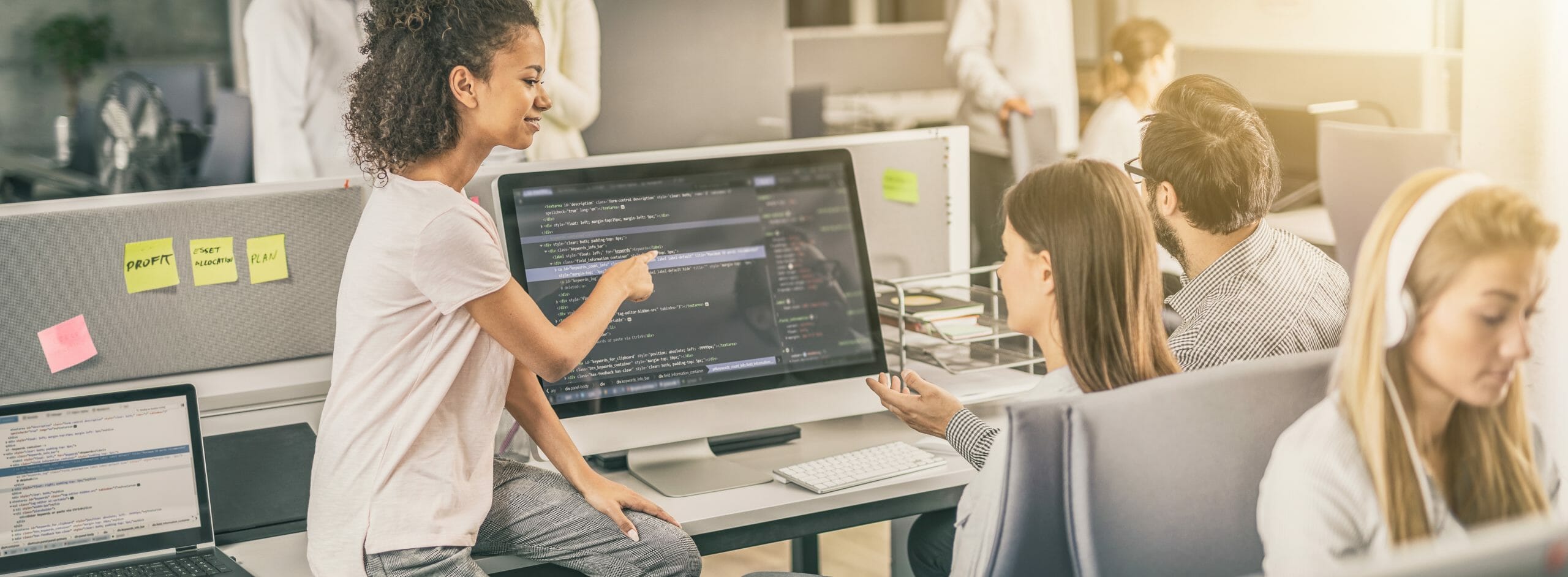 Group of people looking at a computer screen with coding