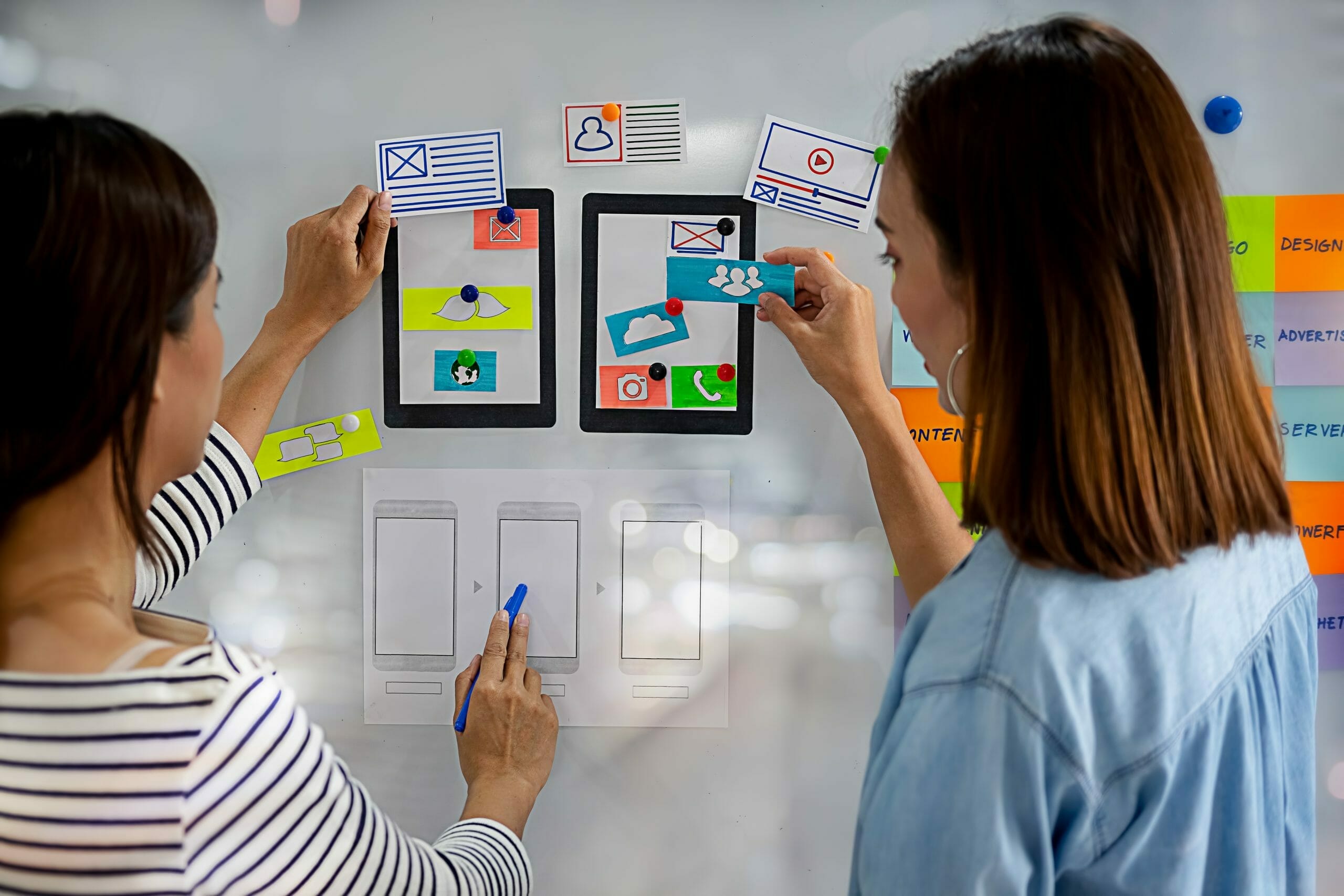 Two women looking at tablets