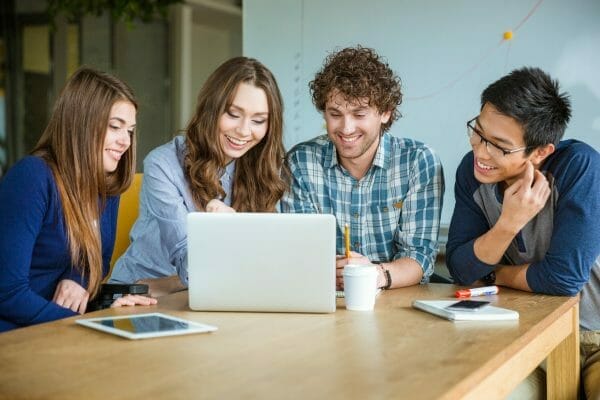 Group of people working together at a laptop