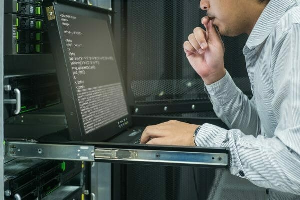 Man hunched over a computer thoughtfully working