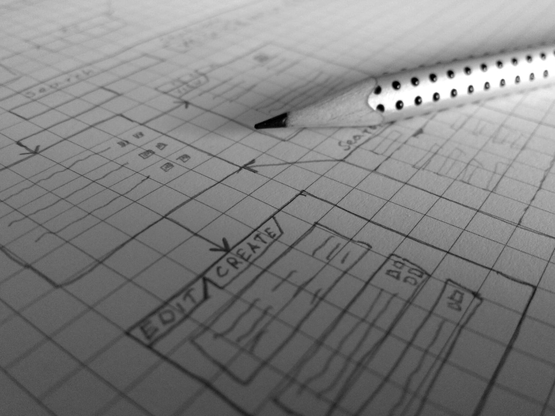 Pencil and graph paper with illustration of software plans